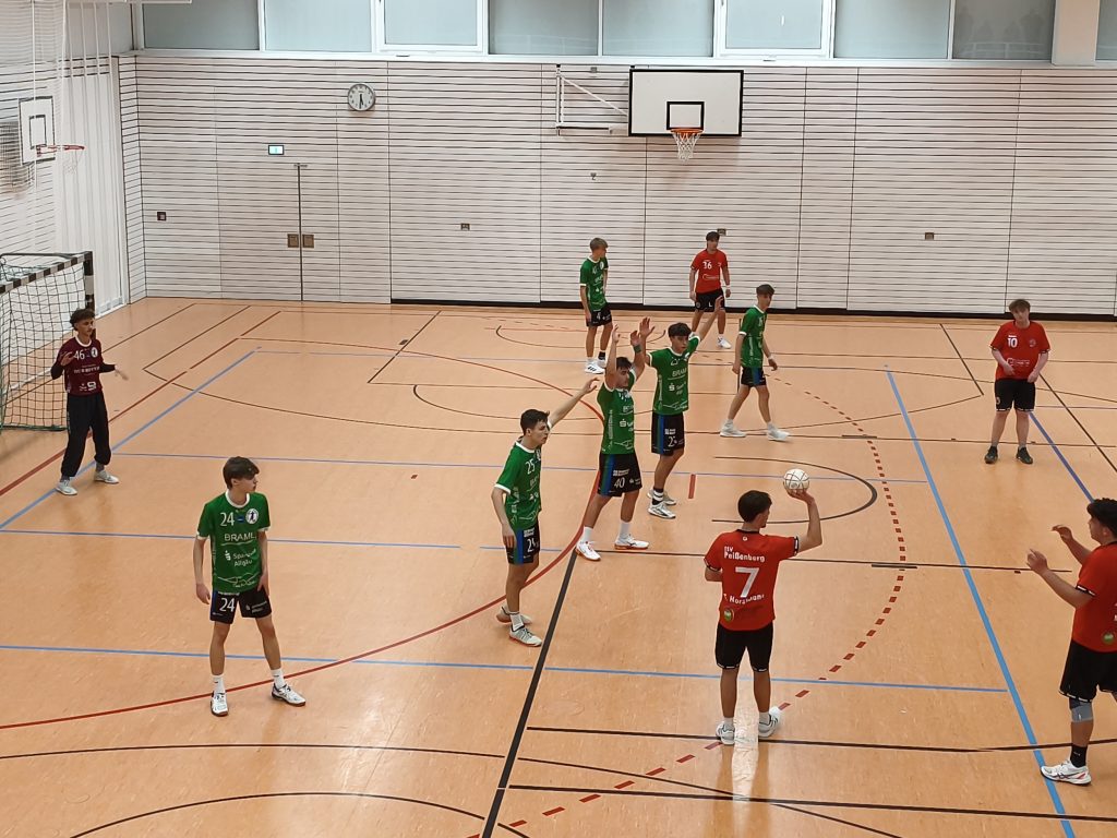 Bild zeigt einen Peißenberger mit dem Ball in der Hand und einen Wurf zum Mitspieler.